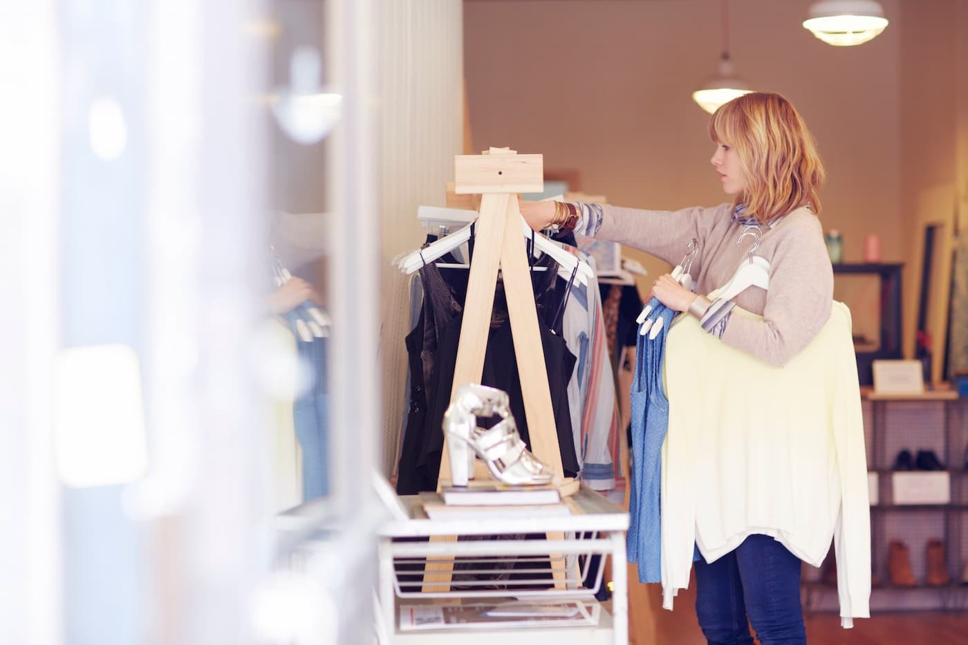 boutique-owner-hanging-up-clothes-on-rack