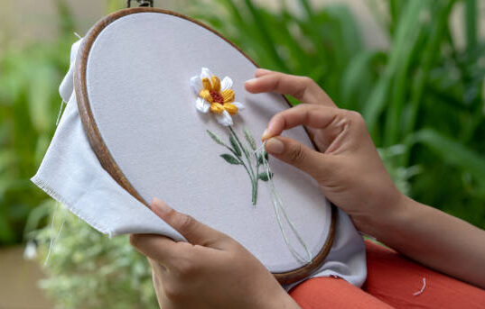 A woman hands embroidering flower on a cloth for relaxing
